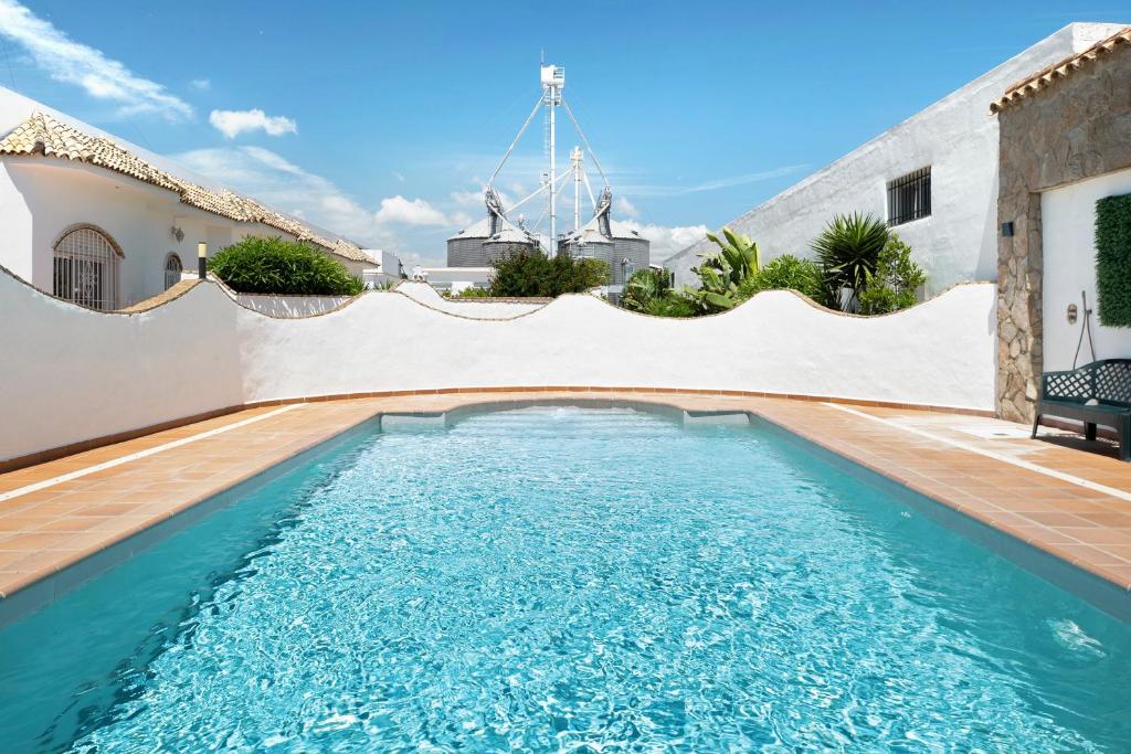 a swimming pool in the backyard of a house at Chalet Fuente3 piscina común famila in Conil de la Frontera