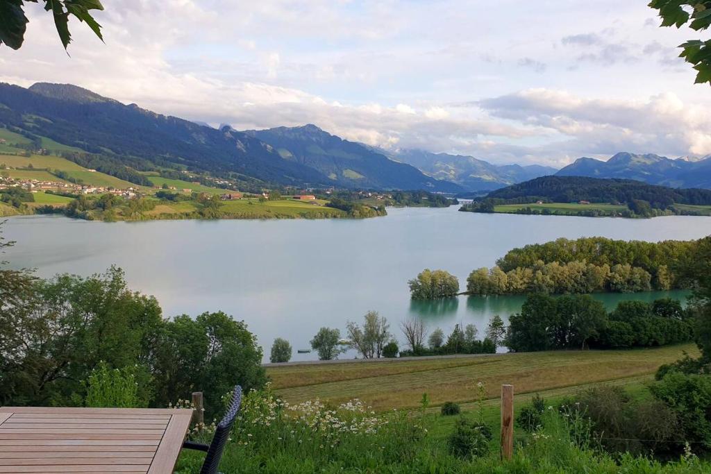 - une vue sur un lac avec des montagnes en arrière-plan dans l'établissement 2 bedrooms apartement with lake view enclosed garden and wifi at Pont en Ogoz, à Avry devant Pont