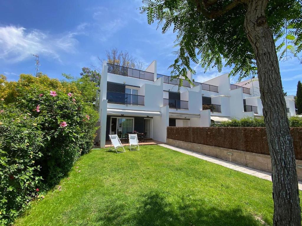 a white house with two chairs in a yard at Fontanilla 58 Casa Lucia with pool and garage at Playa Conil in Conil de la Frontera