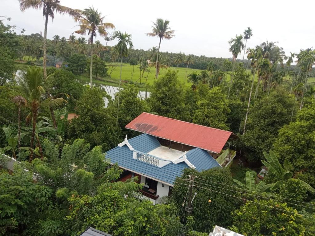 an aerial view of a house with a blue roof at Dragster Homes in Kizhake Chālakudi