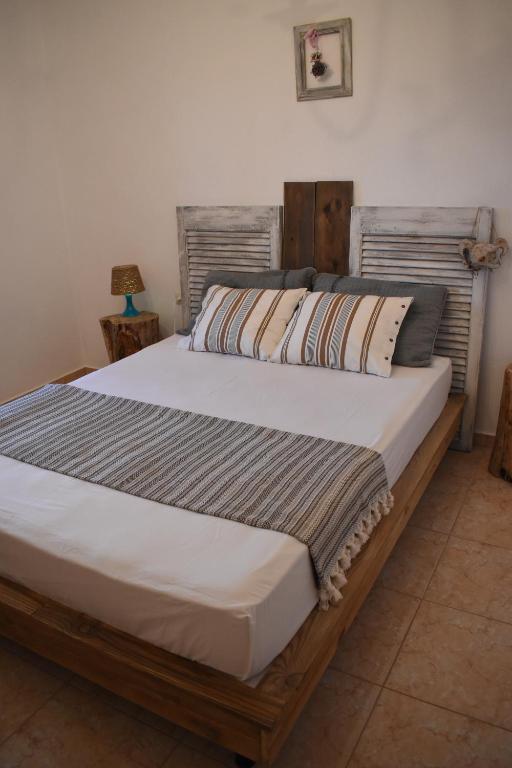 a bedroom with a large bed with a wooden headboard at Mariana's Apartment in Vatopedi