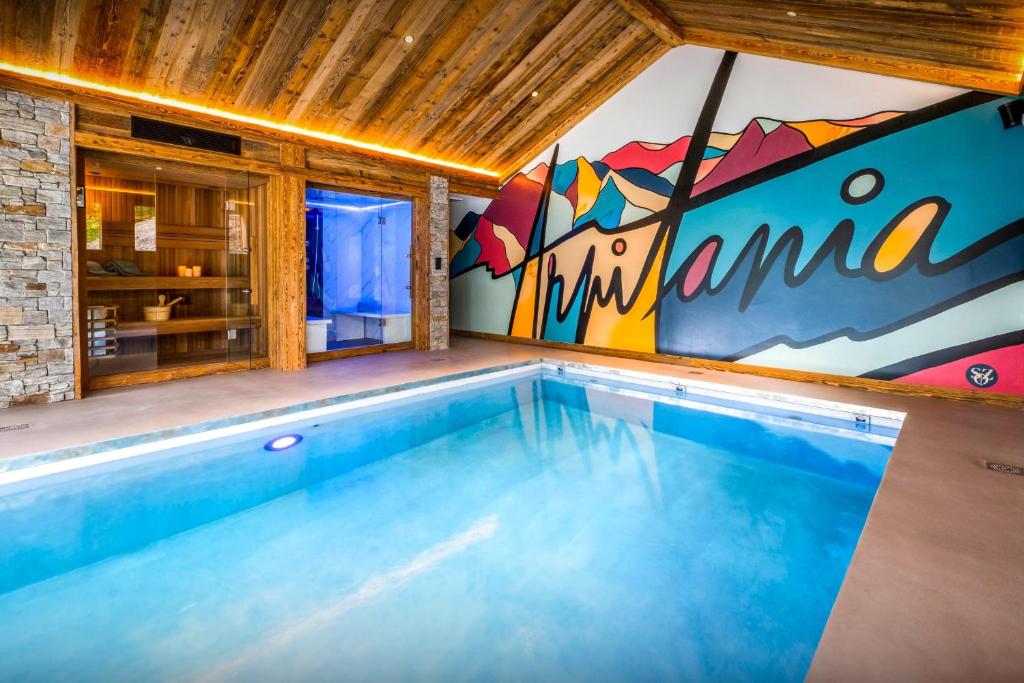 a swimming pool in a house with a mural at Chalet Arpitania - OVO Network in La Clusaz