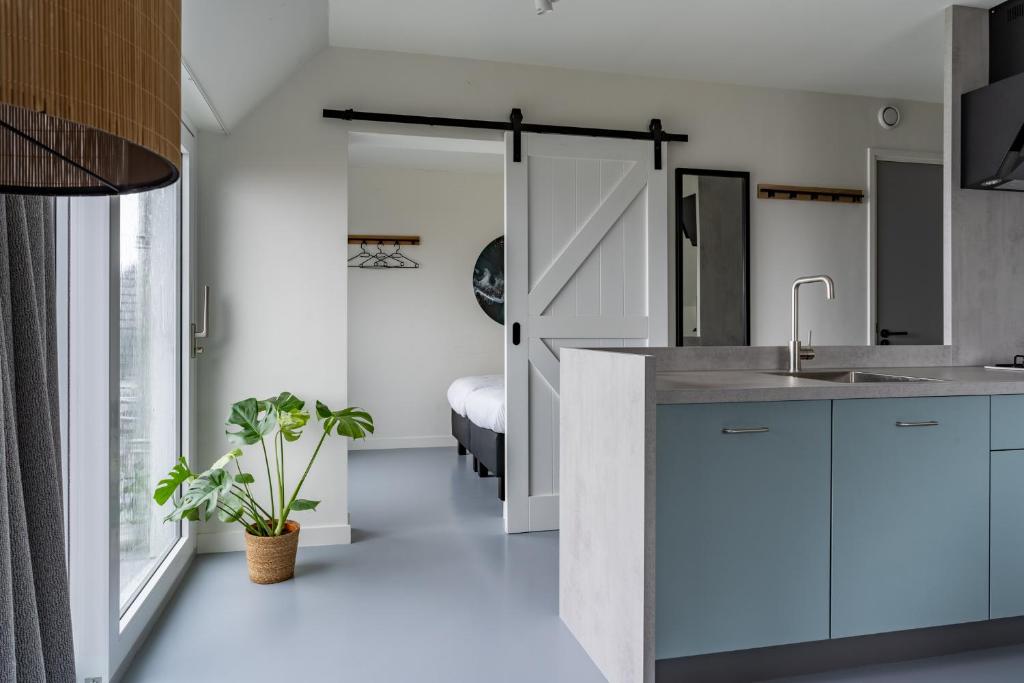 uma cozinha com armários brancos e um lavatório em SneekermeerZicht em Offingawier