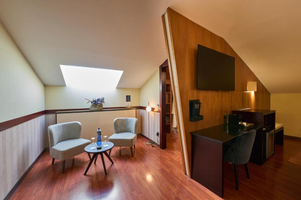 a living room with a table and chairs and a television at Catalonia El Pilar in Zaragoza