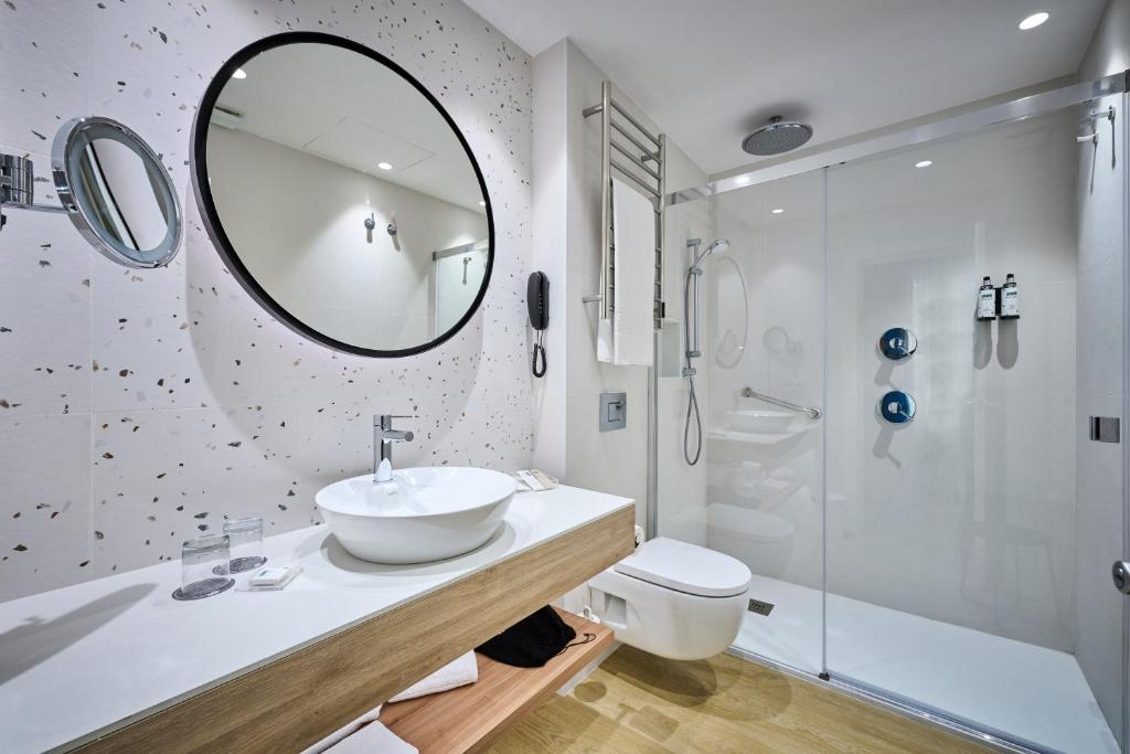 a bathroom with a sink and a mirror and a shower at Catalonia El Pilar in Zaragoza