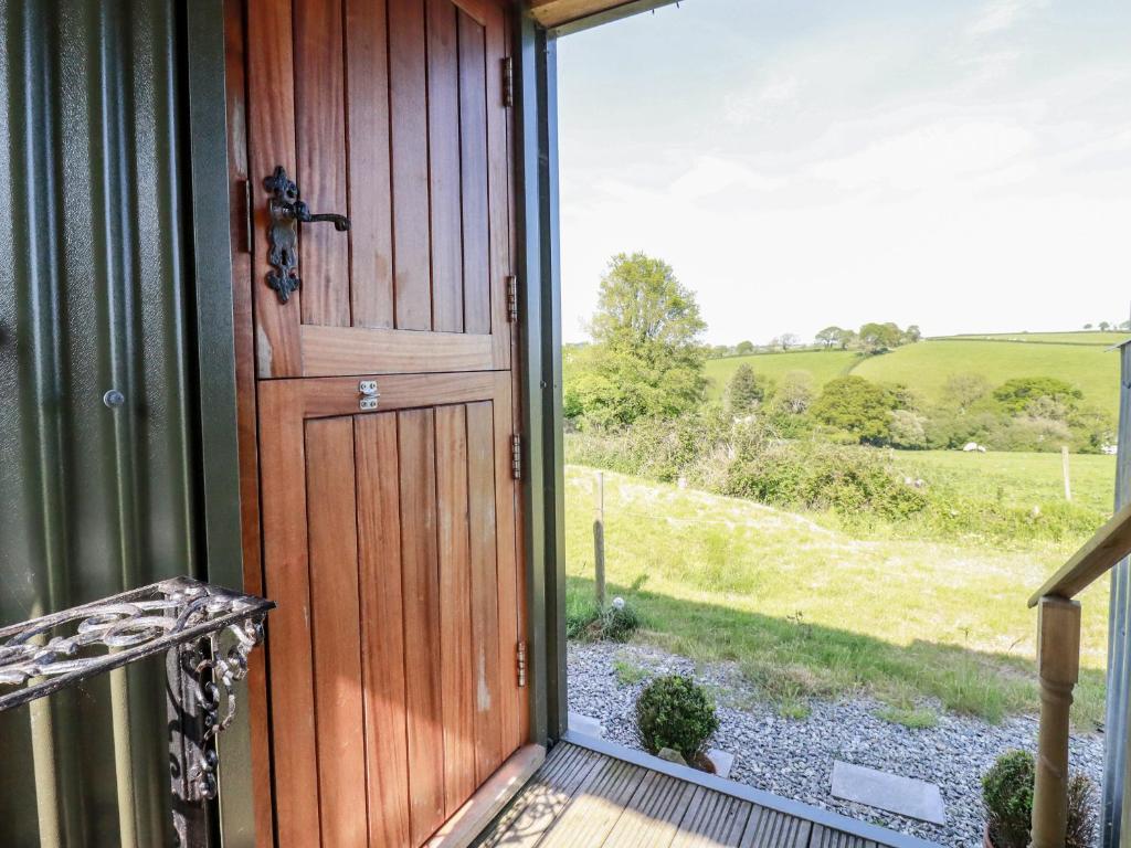 a door to a house with a view of a field at Puddle Duck Shepherds Hut in Launceston