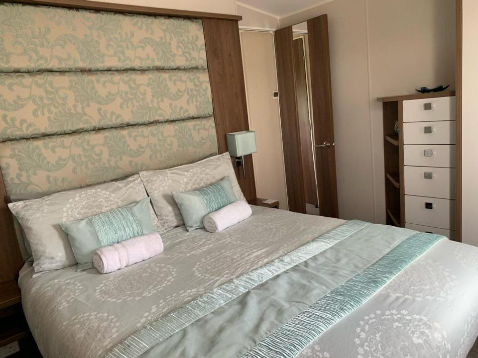 a bedroom with a large bed with two pillows at Tide Away Anderby Creek in Anderby