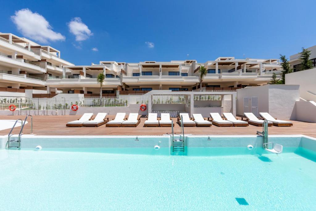 a swimming pool in front of a large apartment at Jardiana Lotus - Walking distance to La Cala De Mijas in La Cala de Mijas