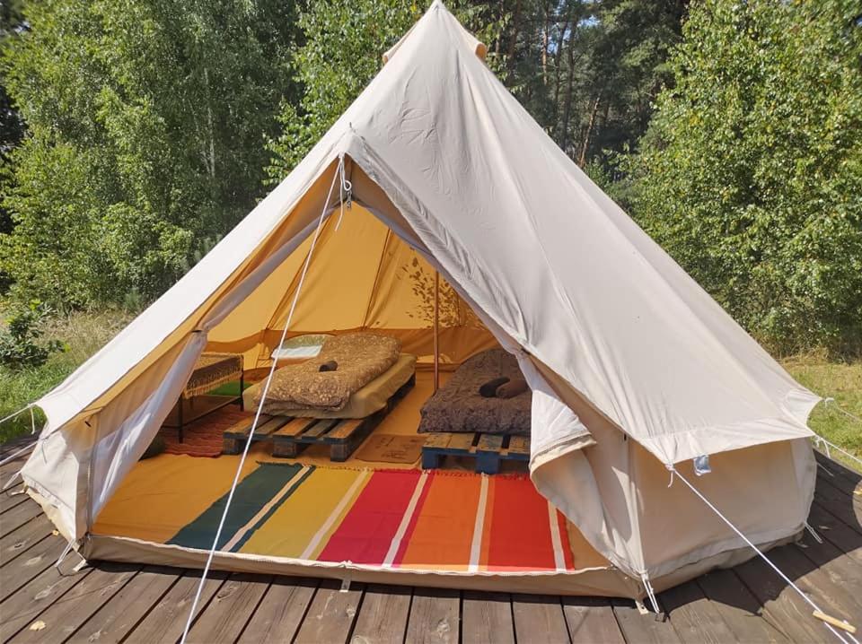 a tent with a rainbow colored rug on a wooden deck at Magic forest 