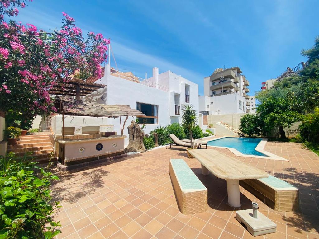 a patio with a picnic table and a swimming pool at Villa urbana con Piscina en Playa den Bossa in Ibiza Town