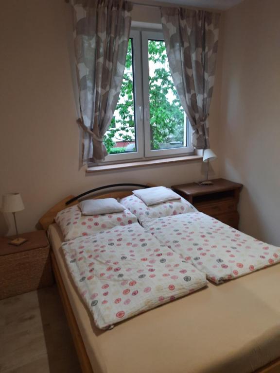 Bett in einem Schlafzimmer mit Fenster in der Unterkunft U Anny in Wałcz
