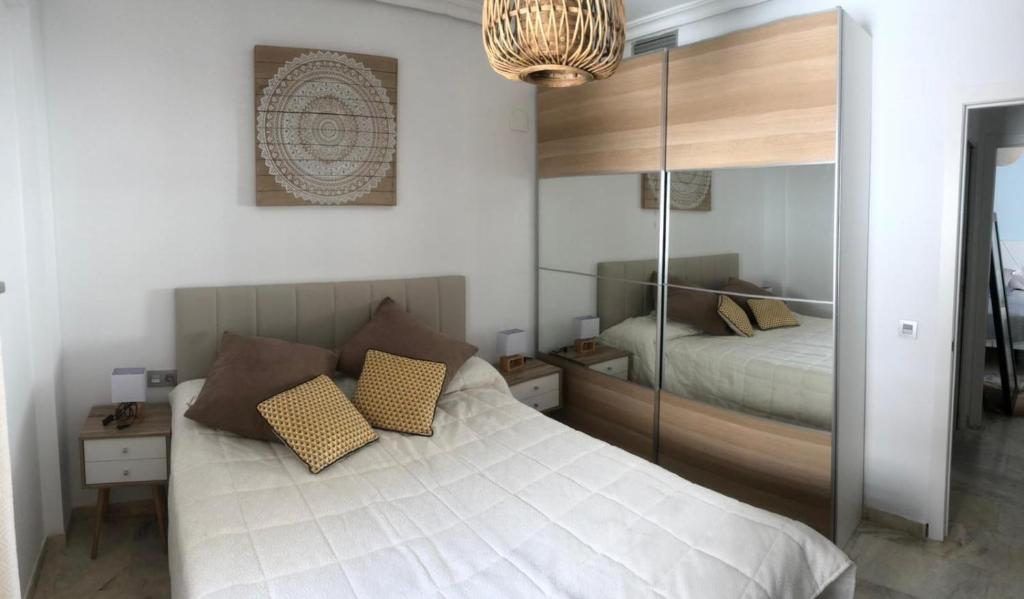 a bedroom with a bed with a mirrored wall at San Jacinto 69 Triana in Seville