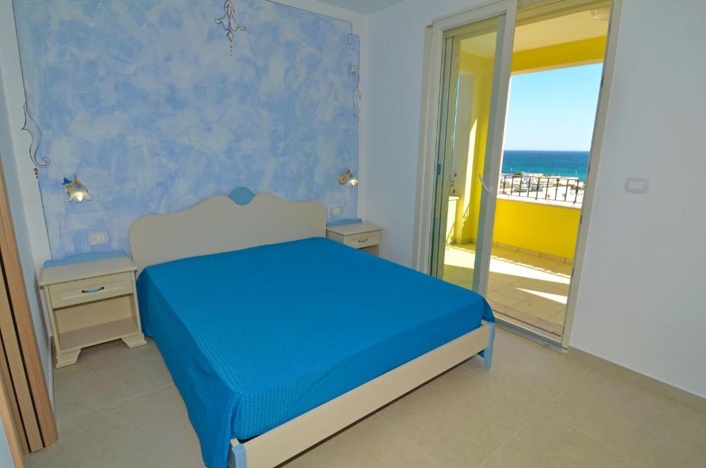 a bedroom with a bed and a view of the ocean at B&B Lu Cantoru in Marina di Pescoluse