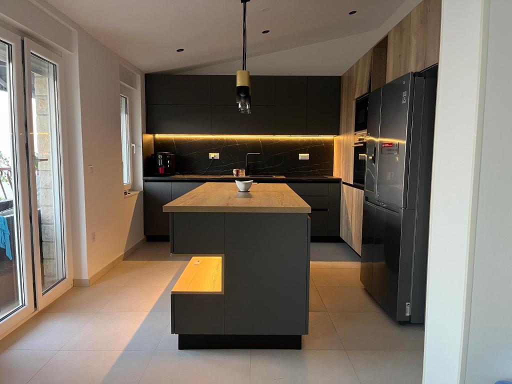 a kitchen with black cabinets and a island in it at Villa La Domazet in Podstrana