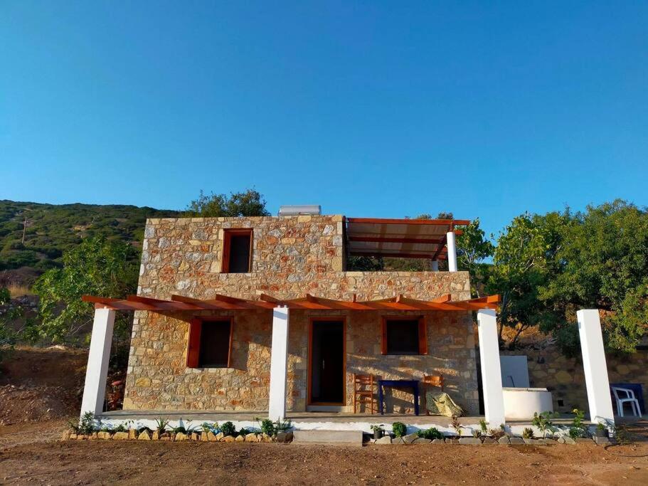 a stone house with a balcony on top of it at Beach Villa Lipsi Island Getaway in Lipsoi