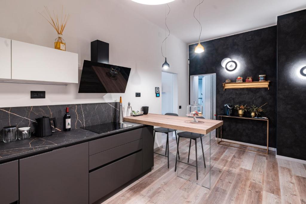 una cocina con electrodomésticos en blanco y negro y una mesa de madera. en Sacrati 39, en Ferrara