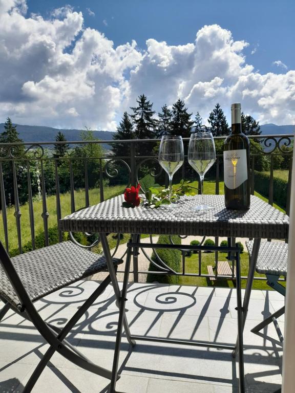 a table with a bottle of wine and two glasses at Agritur Belsogno B&B in Brez