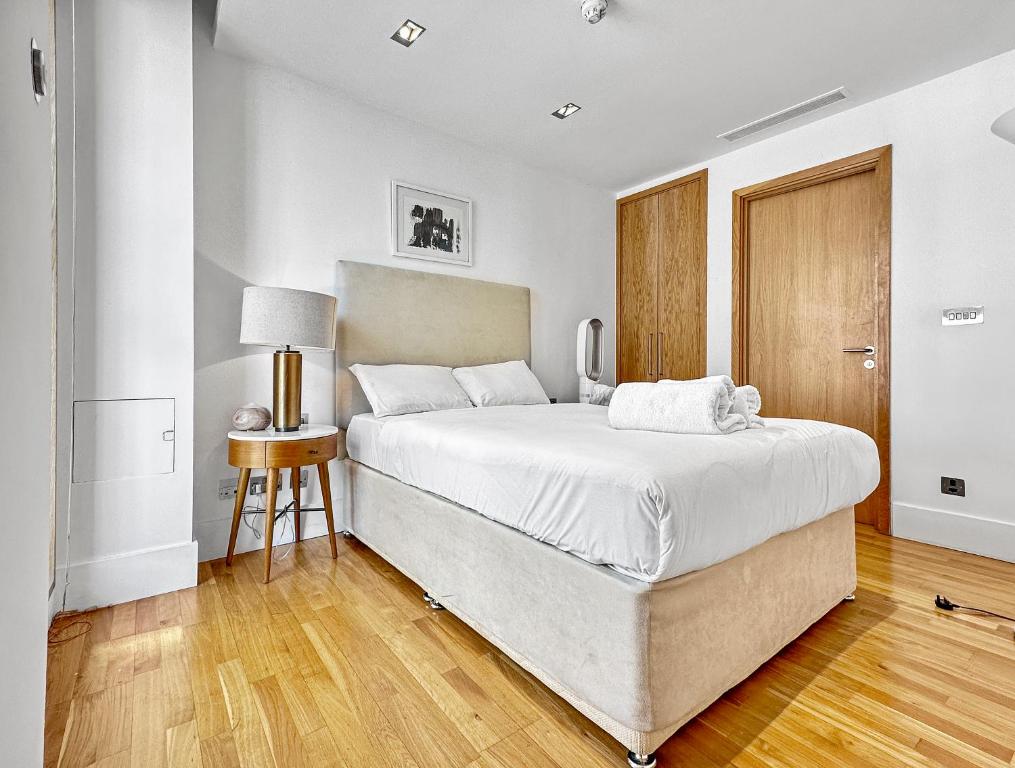 a bedroom with a large bed and a wooden floor at Imperial Piccadilly Apartments in London