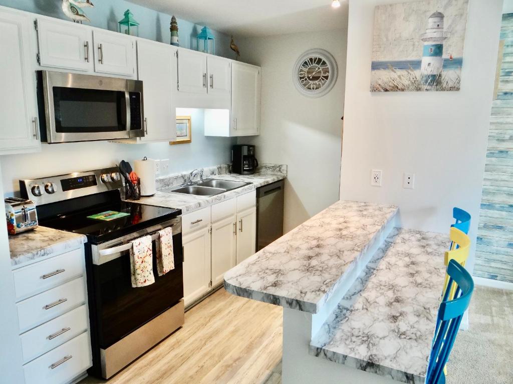 a kitchen with white cabinets and a black appliances at 215 C2 GP-The Treehouse in Coffeyville