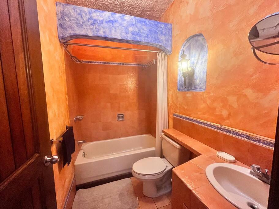 y baño con aseo, bañera y lavamanos. en Casa Villas del Pacifico Puerto San José, en Puerto San José