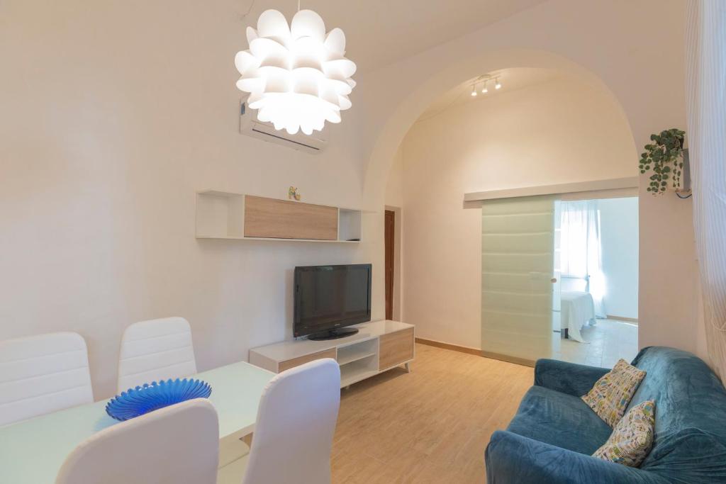 a living room with a blue couch and a television at La Corte by HelloElba in Portoferraio