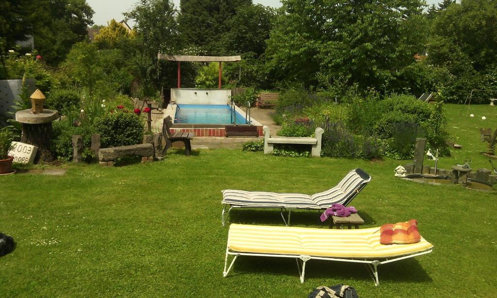 un patio con un banco y una piscina en Apartment Idyle, en Bornheim