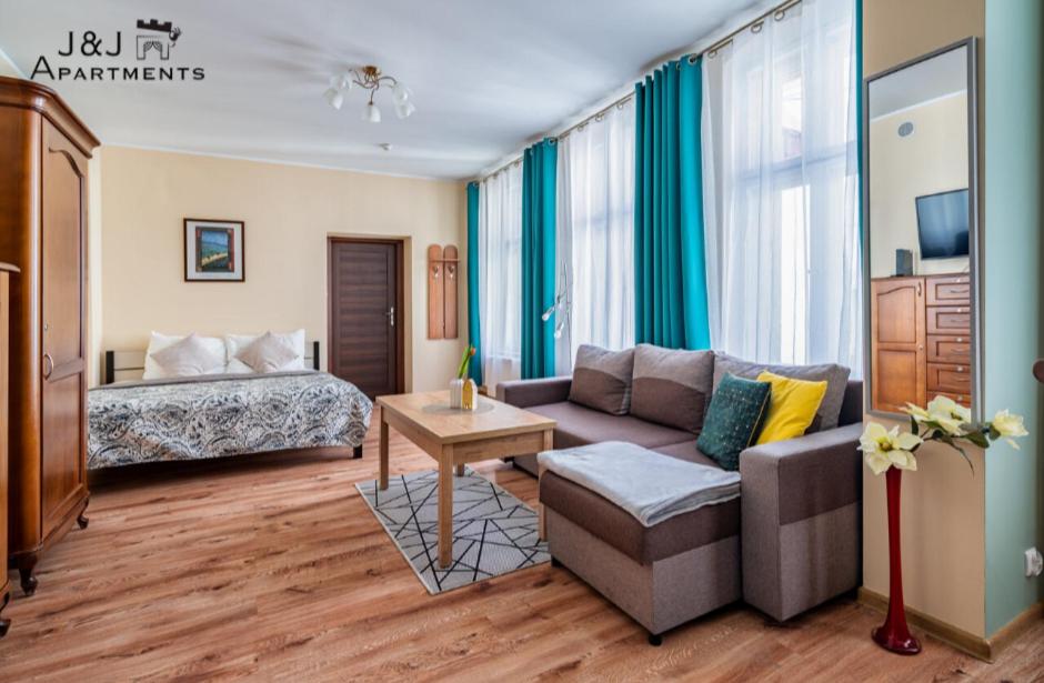 a living room with a couch and a bed at J&J Apartments Łazienna 30 Apartament 10-5 in Toruń