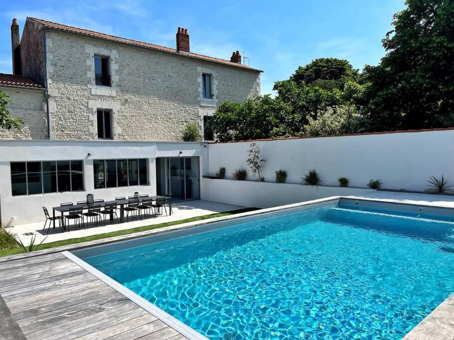 une piscine devant une maison dans l'établissement L'échappée - Villa avec piscine, à La Genilliere