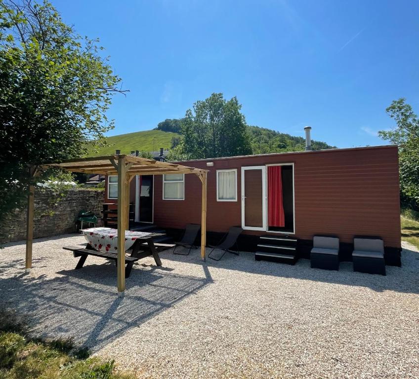 a small cabin with a picnic table and a tent at Le Murmont in Thonnance-lès-Joinville