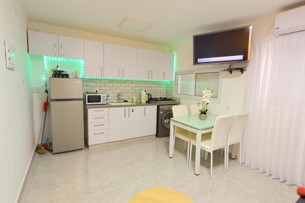 a kitchen with a table and a refrigerator at דירה יפה סגנון מודרני מרחק של 5 דקות נסיעה מהים in Ashkelon