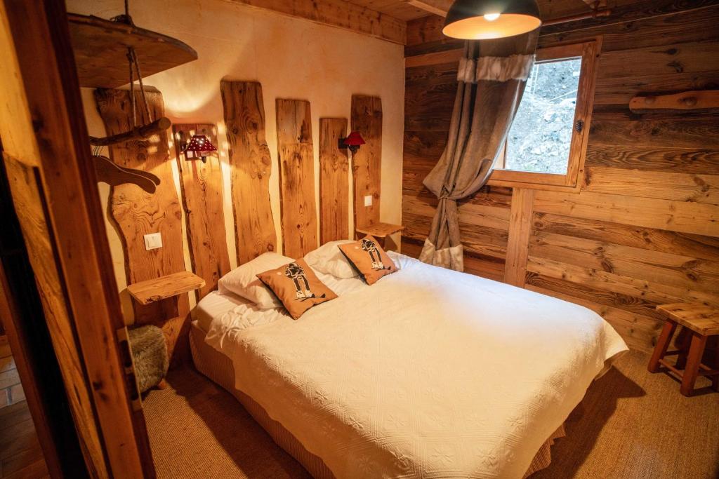 ein Schlafzimmer mit einem Bett in einem Blockhaus in der Unterkunft Savoya Lodges in Châtel
