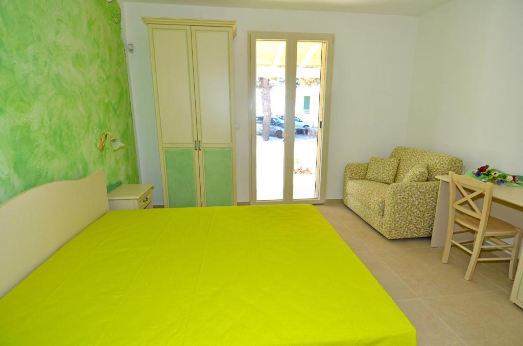a bedroom with a large yellow bed and a chair at B&B Lu Cantoru in Marina di Pescoluse