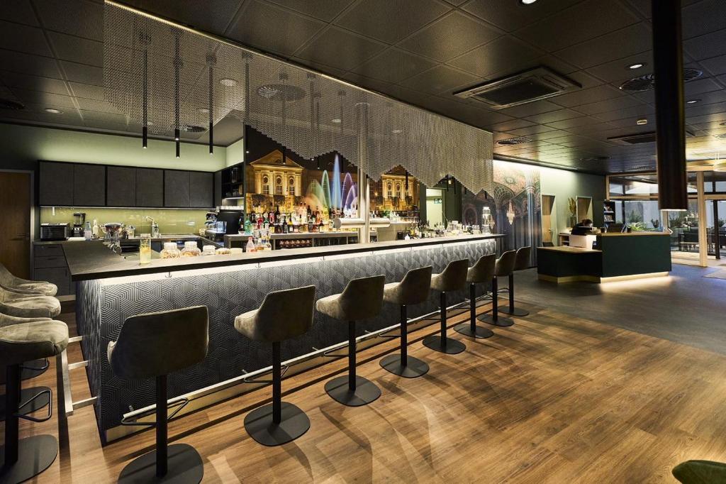 a bar with a row of bar stools at Hotel Rhönkitz in Bad Kissingen