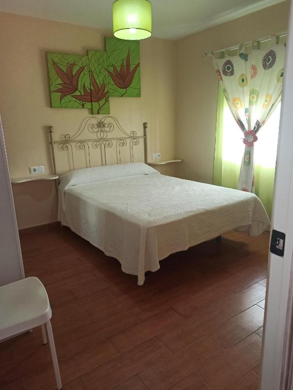 um quarto com uma cama branca e uma janela em MIS NIÑAS em Conil de la Frontera
