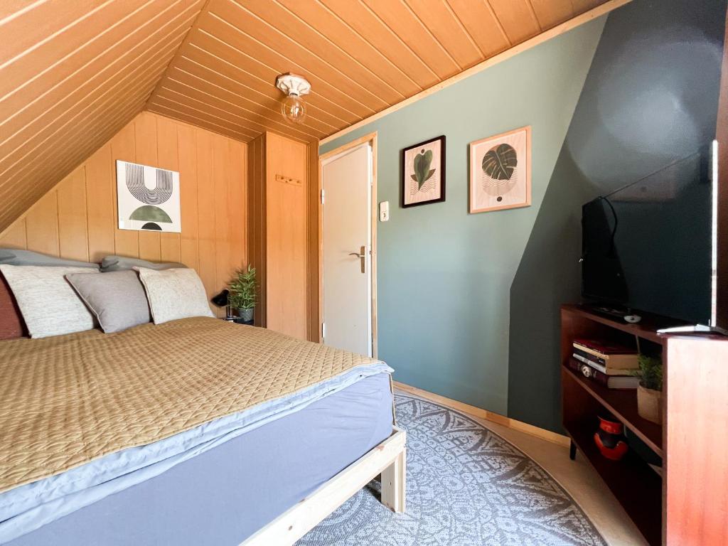 a bedroom with a bed and a flat screen tv at "Ohuus" Ferienhaus mit Garten in Büsum