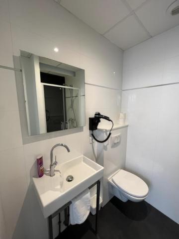 a white bathroom with a sink and a toilet at Residence OLit Cathédrale in Strasbourg