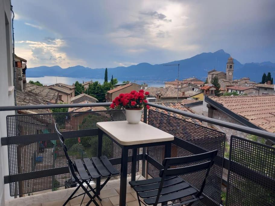 a table and chairs on a balcony with a vase of flowers at Casa Maria in Torri del Benaco