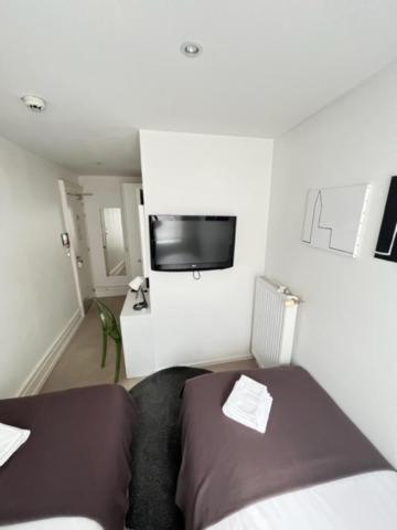 a bedroom with two beds and a flat screen tv at Residence OLit Cathédrale in Strasbourg