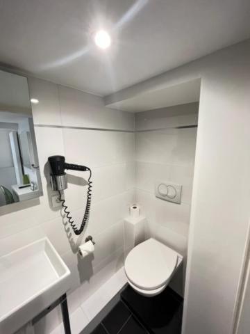 a bathroom with a toilet and a phone on the wall at Residence OLit Cathédrale in Strasbourg
