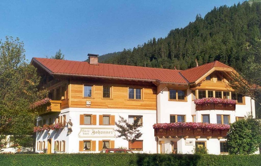 uma grande casa de madeira com um telhado vermelho em Pension Johannes em Bach