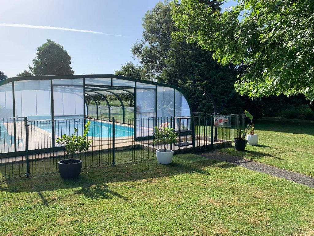 a fence with potted plants in front of a pool at Domaine des Trois Rivières in Merlevenez