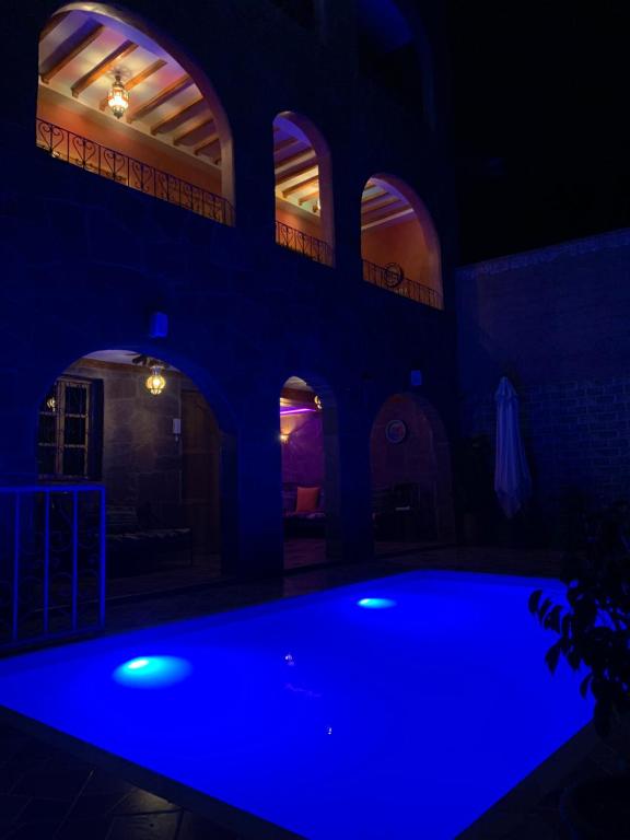 a house with a blue pool in the dark at DAR EL HACHIMI EL IDRISSI in Ourika