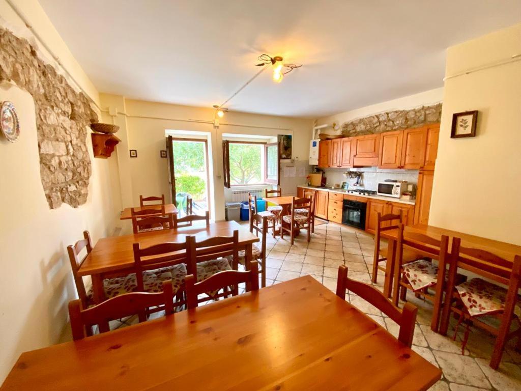 a kitchen and dining room with wooden tables and chairs at Affittacamere Porta Majella in San Valentino in Abruzzo Citeriore