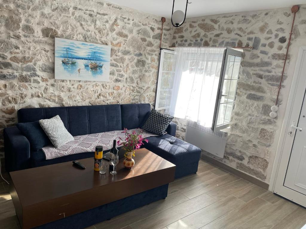 een woonkamer met een blauwe bank en een tafel bij Filipa Apartment in Limenas