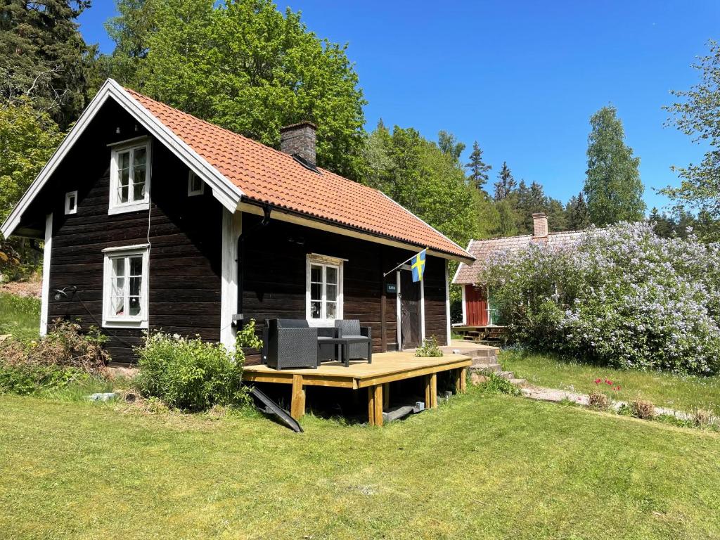 a small house with a picnic table in front of it at Cozy holiday home in Tranas, Odeshog in Tranås