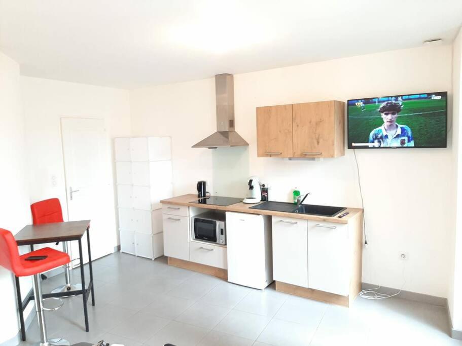 a kitchen with a sink and a counter with a tv at studio hyper-centre confortable acces boite a clee parking in Castres