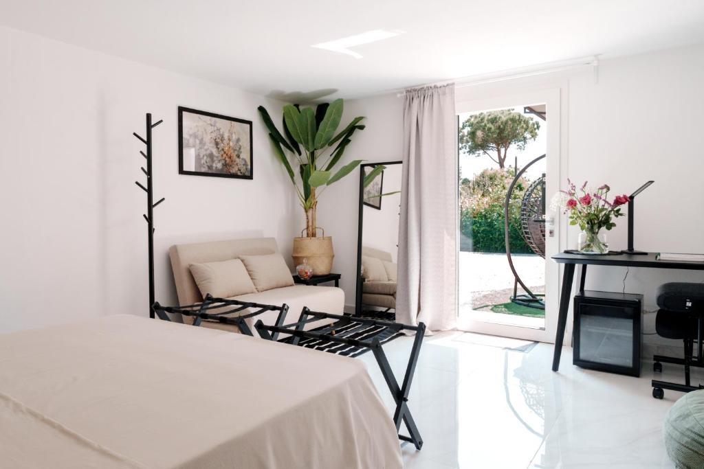 La Stanza del Relax في سان دونا دي بيافي: غرفة بيضاء بسرير واريكة ونافذة