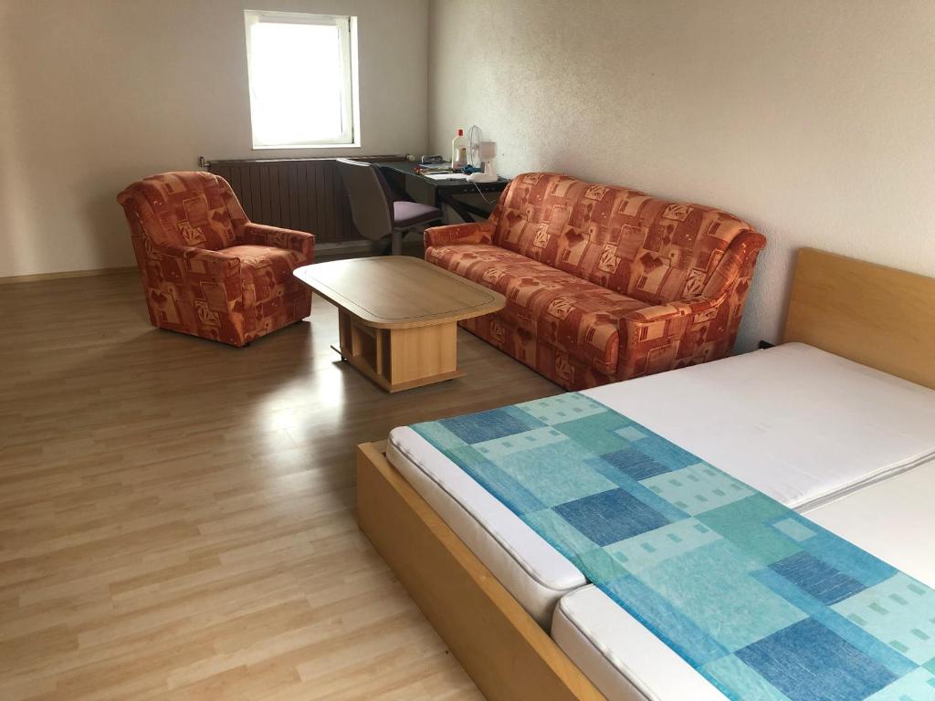 a room with a bed and a couch and chairs at Ferienwohnung in Weilburg in Weilburg