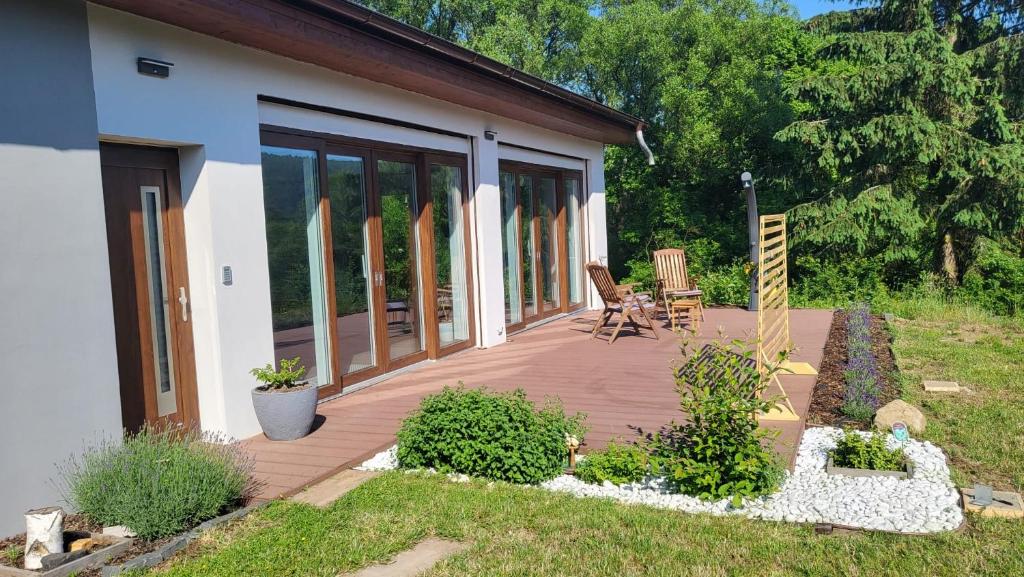 una terraza de madera con una silla en una casa en Apartman s bazénem a saunou en Kadaň