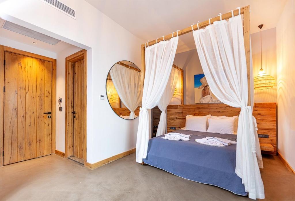 a bedroom with a canopy bed with white curtains at Dmira Alacati in Alaçatı